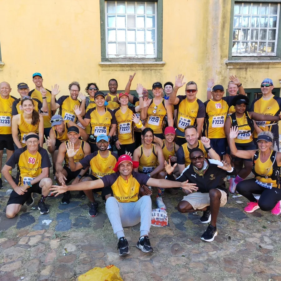 Club members smiling and waving together in their Century City running kit